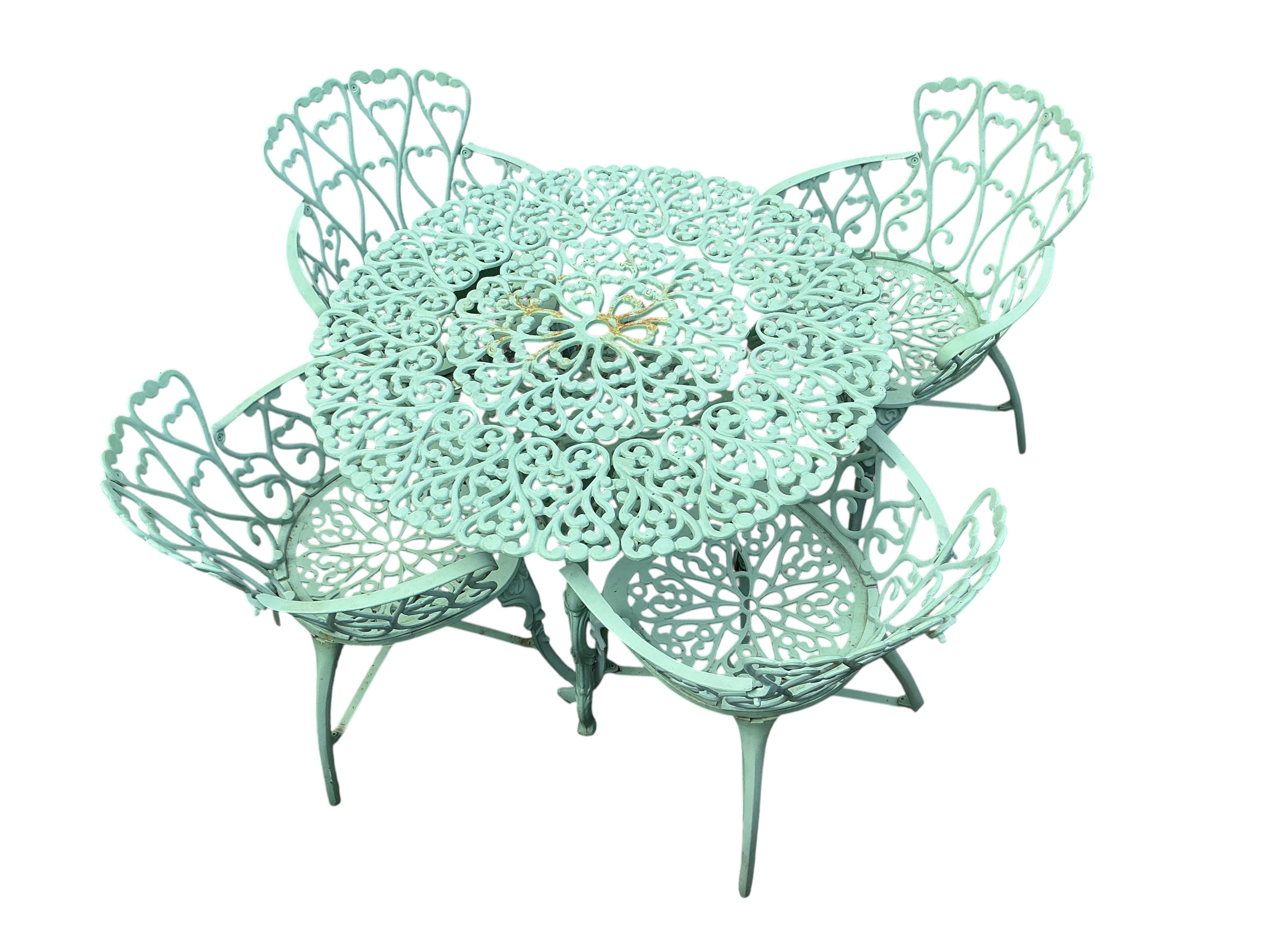 A painted circular aluminium garden table and four chairs, table diameter 99cm, height 69cm